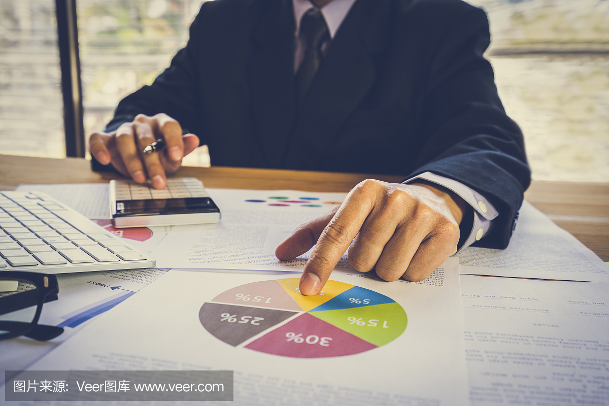 商人或會計工作計算器計算業(yè)務(wù)數(shù)據(jù)的概念。會計、投資顧問咨詢財務(wù)報告的情況,并在辦公室策劃營銷計劃。